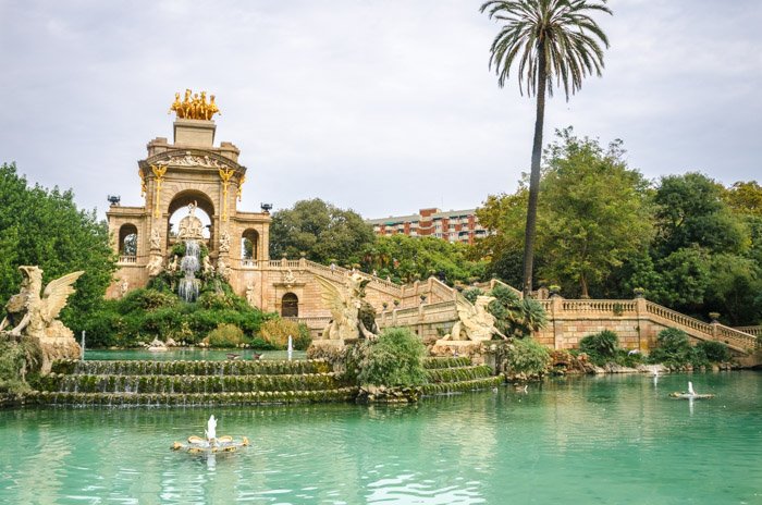 foto de un hermoso parque en Barcelona con un lago y fuentes
