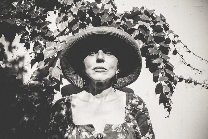 imagen de película en blanco y negro de una mujer con sombrero y blusa floral