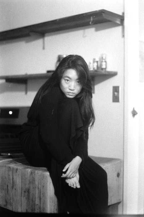 fotografía en blanco y negro de una mujer posando con la cabeza apoyada en la rodilla