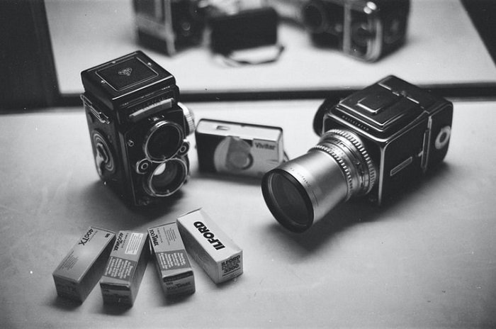 imagen en blanco y negro de una cámara de cine con rollos de película