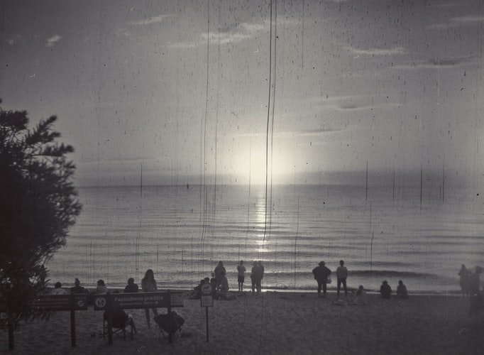 fotografía en blanco y negro de la puesta de sol en una playa