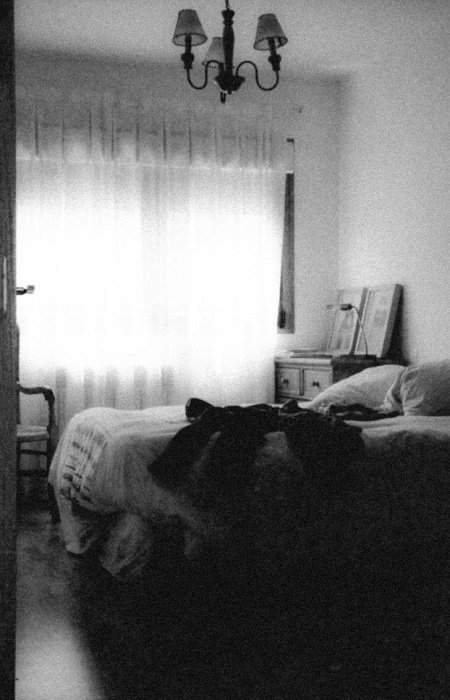 fotografía en blanco y negro de un dormitorio con grano de película alto