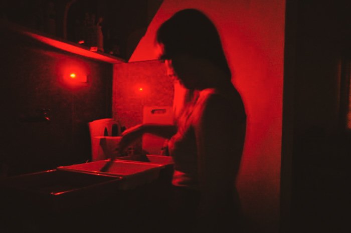 Una niña revelando película en un cuarto oscuro de bricolaje