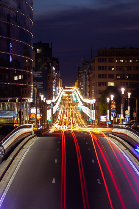 Estelas de luz de tráfico en una carretera que atraviesa una ciudad por la noche
