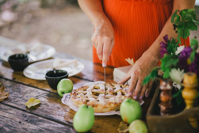 foto de una mujer cortando un pastel