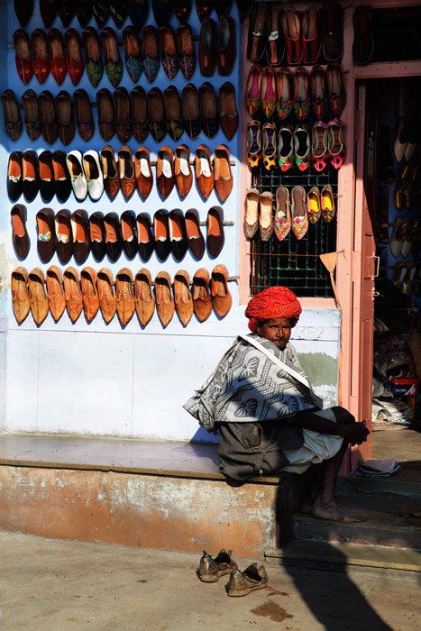 un vendedor ambulante sentado junto a un puesto hisi
