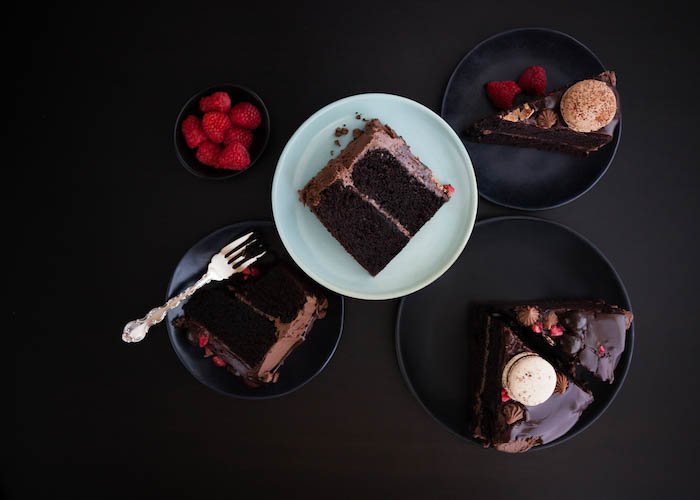 Rebanadas de pastel de capa de ganache de chocolate sobre fondo oscuro