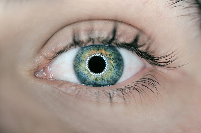 Un impresionante primer plano del ojo verde de una persona usando fotografía con luz anular