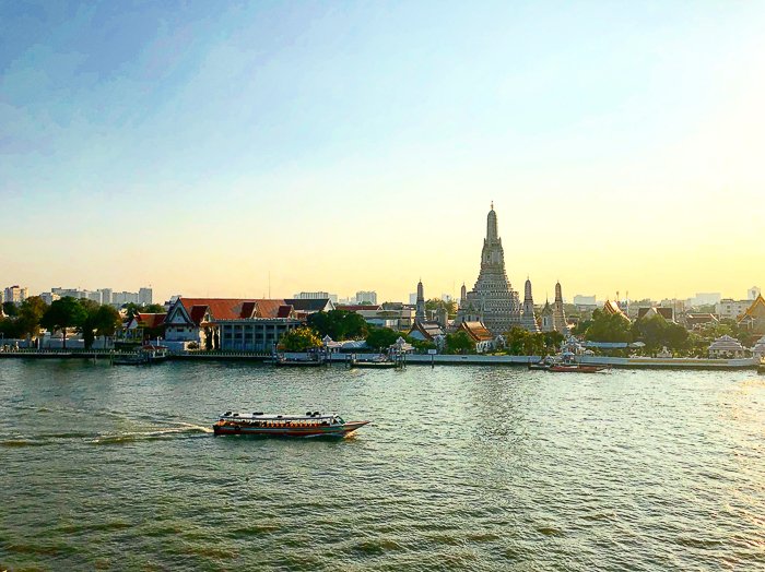 Un paisaje urbano bastante pintoresco junto a un río en un día brillante en el momento en que pasa un barco colorido