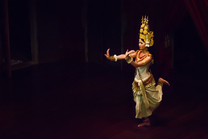 Fotografía de viaje atmosférica de una chica bailando en una habitación con poca luz