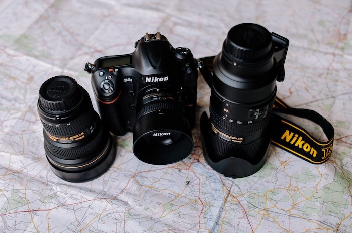 Cámara Nikon DSLR y lentes en la parte superior de un mapa