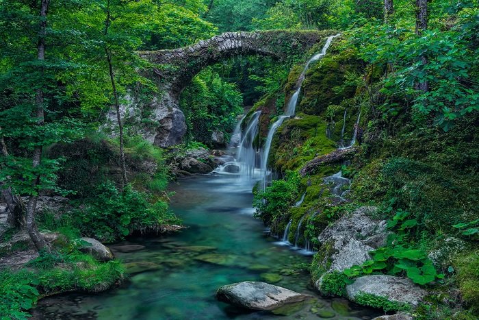 Imagen del puente de piedra sobre un pequeño río