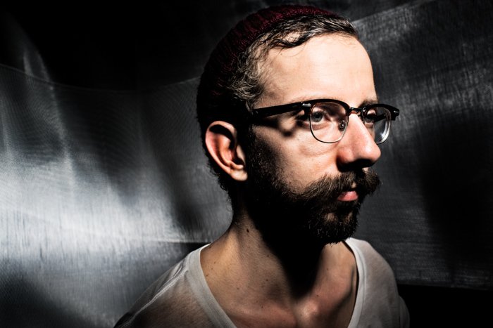 Un retrato de estudio malhumorado de un modelo masculino con gafas - errores de iluminación de fotografía