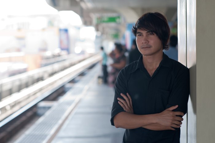 Un modelo masculino posando de pie en una plataforma de tren: consejos de iluminación fotográfica