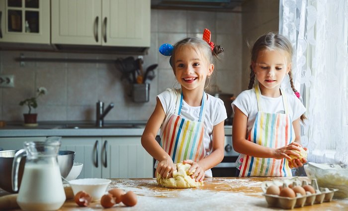 ideas para sesión de fotos de hermanas: dos niñas cocinando en la cocina