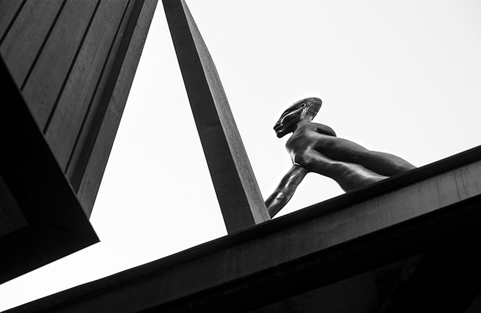 Una foto en blanco y negro de una escultura callejera - iluminación de fotografía callejera