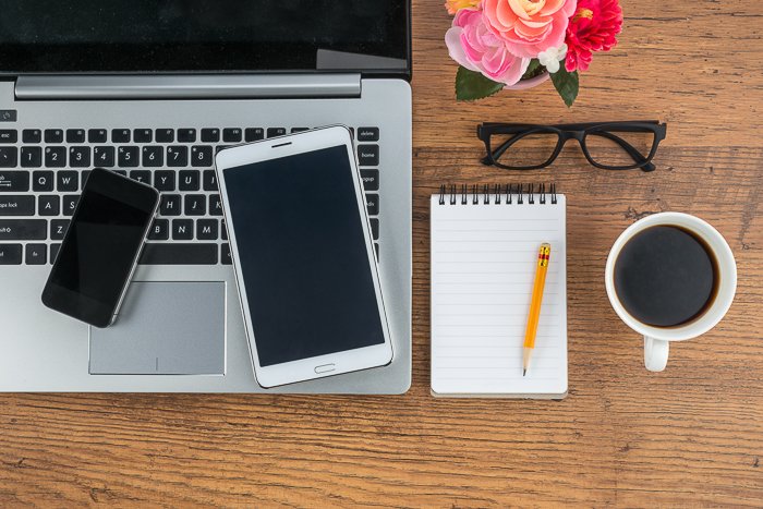 Fotografía cenital de una computadora portátil, un teléfono, una tableta y una computadora portátil: preparándose para enviar fotos