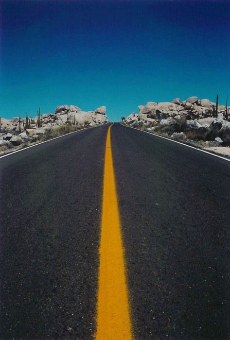 foto de carretera de una carretera que conduce al horizonte, cielo azul y carretera de rayas amarillas