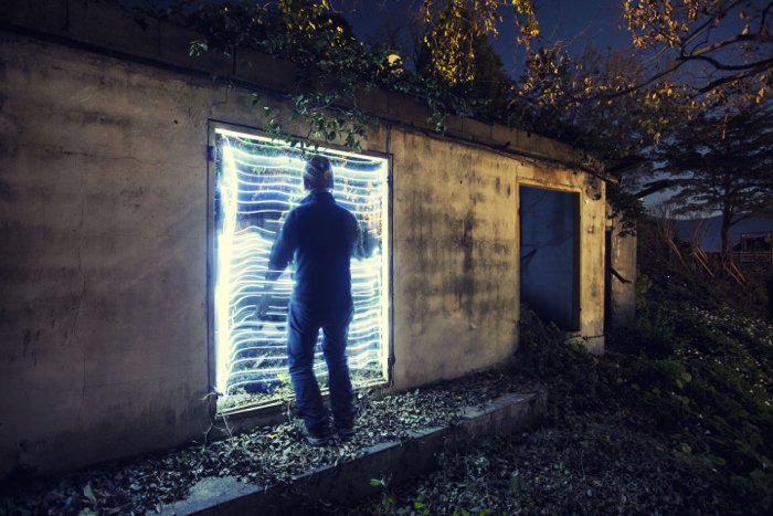 fotografía urbex: retroiluminación fresca detrás de un hombre explorando un edificio abandonado
