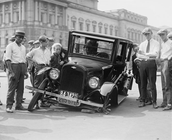 fotografía vintage en blanco y negro de un grupo de hombres y niños parados alrededor de un camión vintage averiado