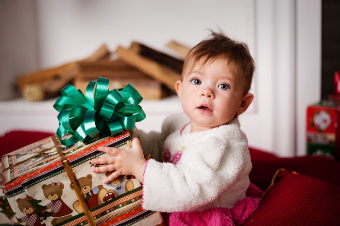 Dulce bebé Foto de Navidad de una niña con un regalo
