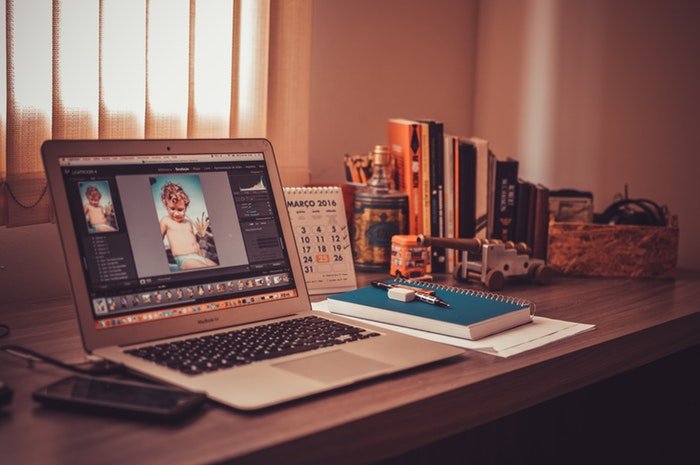 una computadora portátil abierta en una pantalla de edición en una oficina en casa