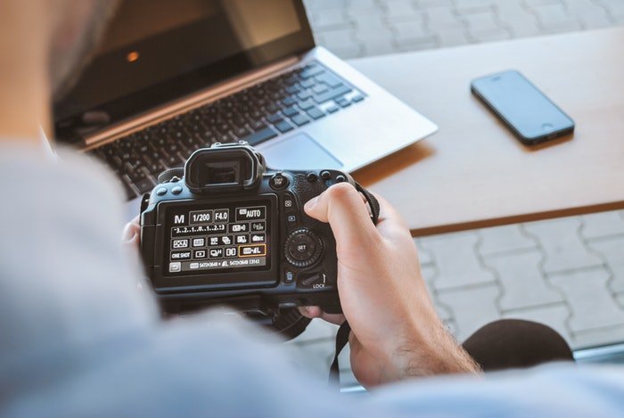 un fotógrafo cambiando la configuración de una DSLR