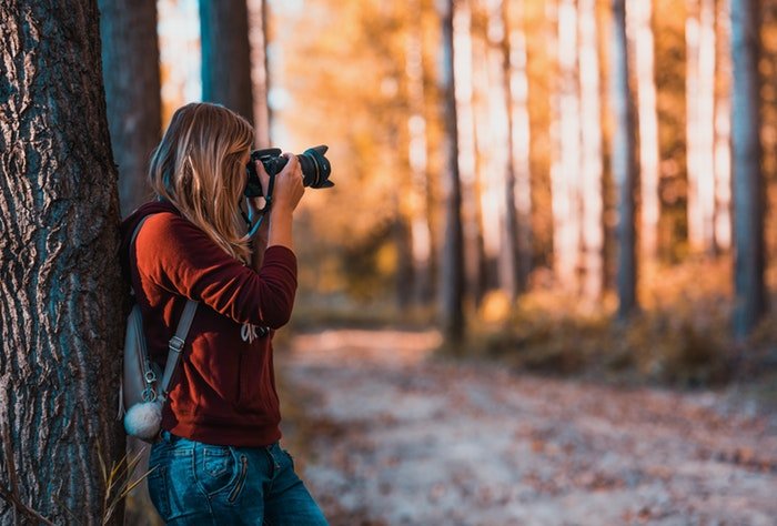 una fotógrafa disparando en un bosque