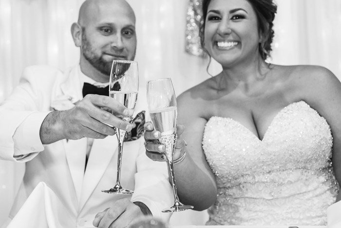 foto de boda en blanco y negro de una pareja de recién casados brindando con champán