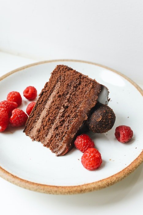 Foto en ángulo alto de un delicioso pastel de chocolate en un plato con bayas