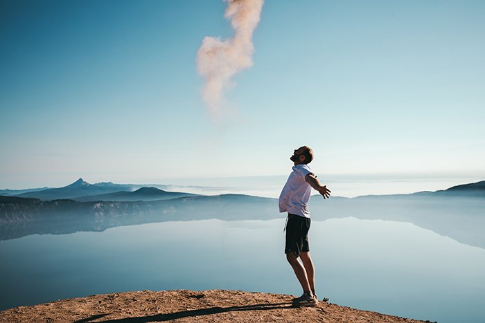 Un retrato sincero de un hombre frente a un paisaje impresionante.