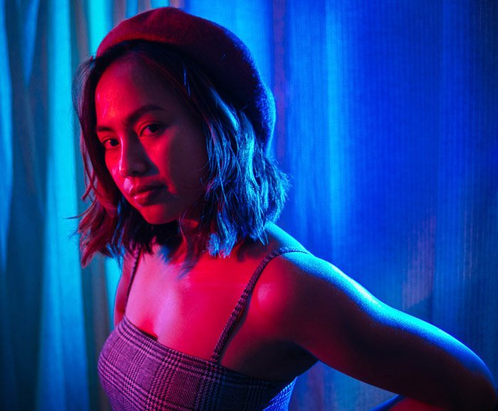 Un espectacular retrato de color azul y rosa de una modelo femenina usando geles de iluminación