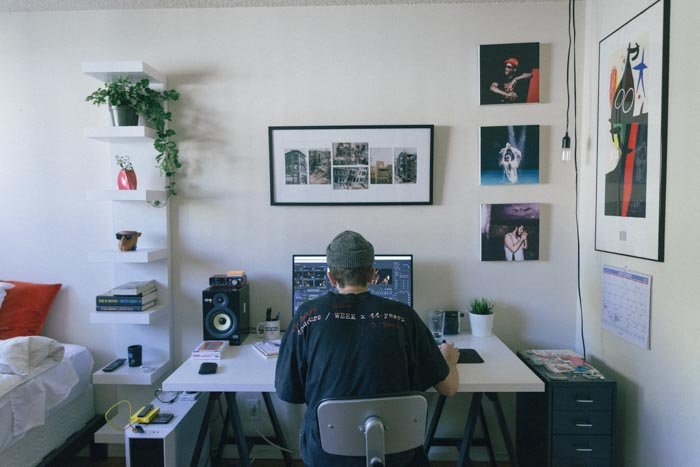 Un hombre editando fotos en una computadora portátil en una oficina en casa