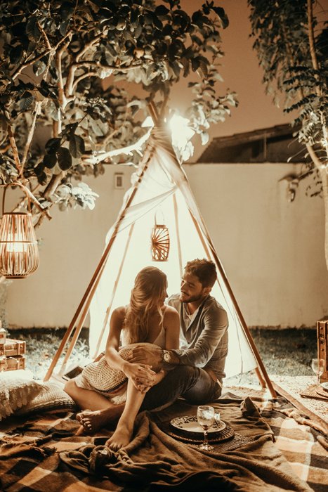 Una pareja abrazándose frente a un tipi