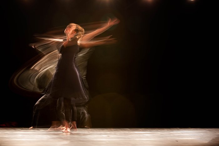 Toma de fotografía de danza atmosférica de una bailarina a mitad de su actuación