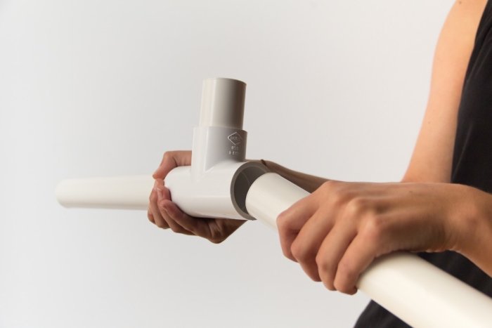 Una persona armando una base de soporte de telón de fondo