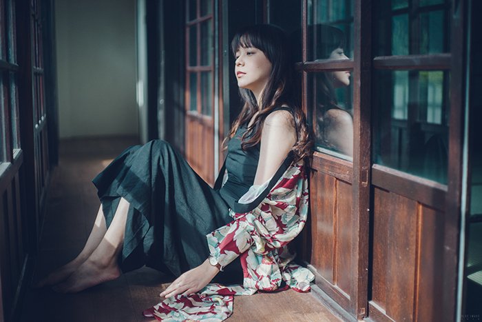 Fotografía artística atmosférica de una modelo femenina sentada en el suelo