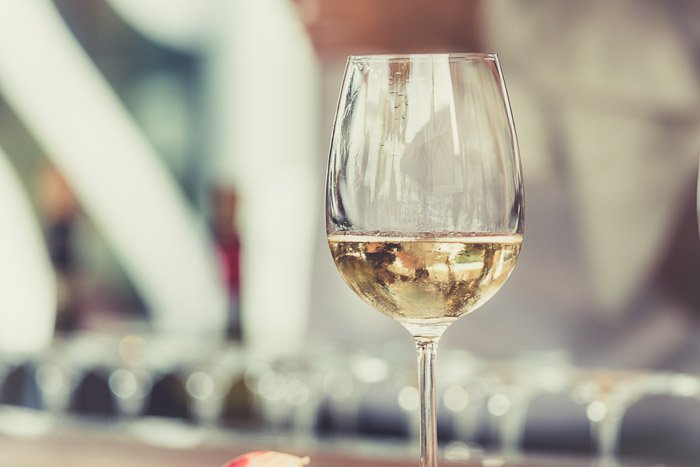 Consejos de estilo de comida: una copa de vino blanco contra un fondo borroso