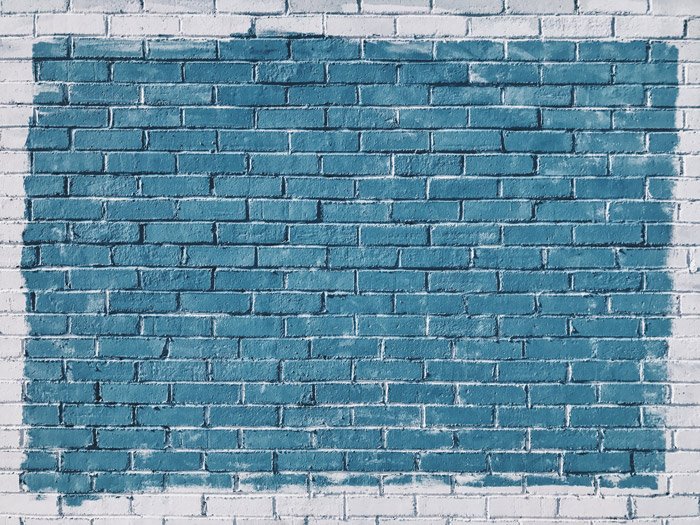 Una pared de ladrillo con textura pintada de azul y blanco - geometría de composición