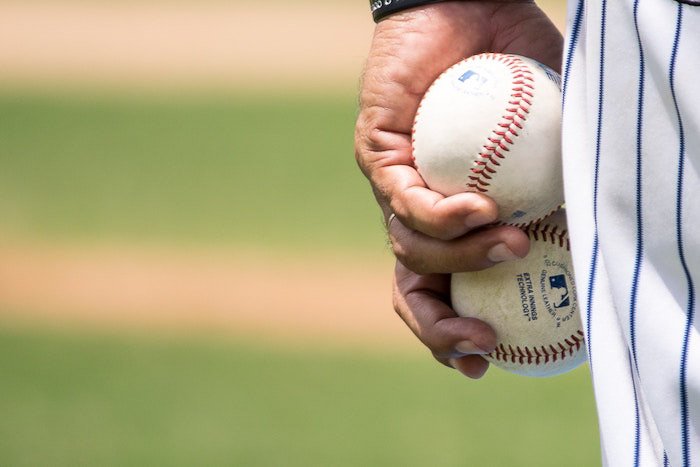 Un primer plano de un jugador de béisbol sosteniendo dos bolas
