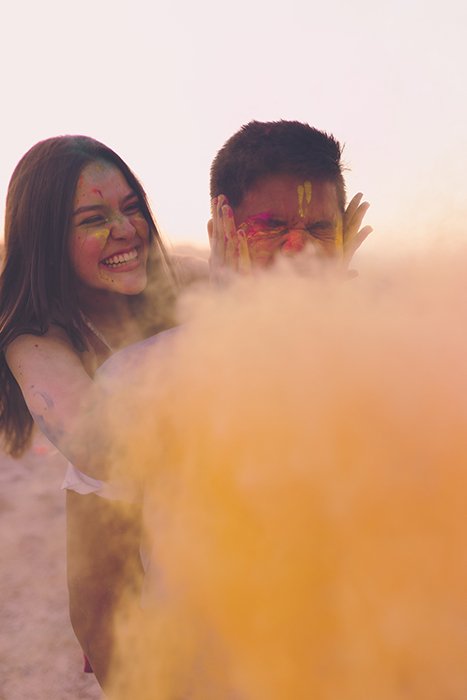 Foto de una niña y un niño con un fondo simple detrás de polvo de color amarillo