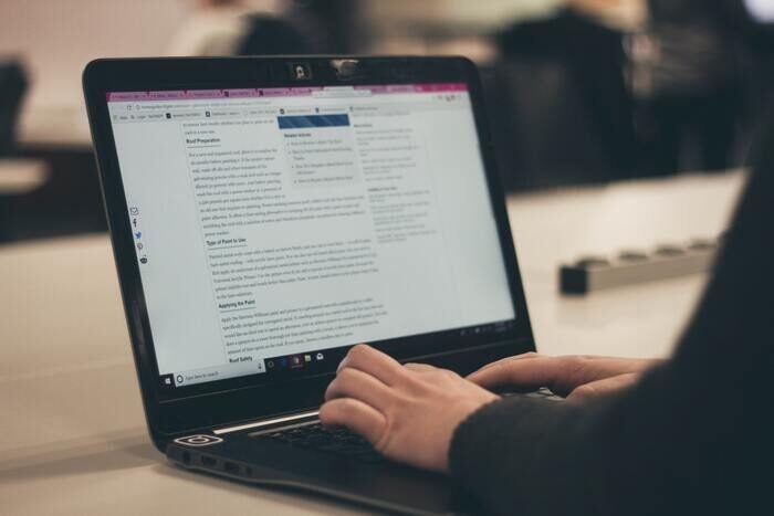Foto de una persona escribiendo en una laptop