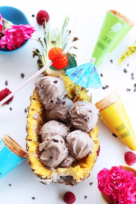 Foto plana de helado afrutado servido en una piña e ingredientes