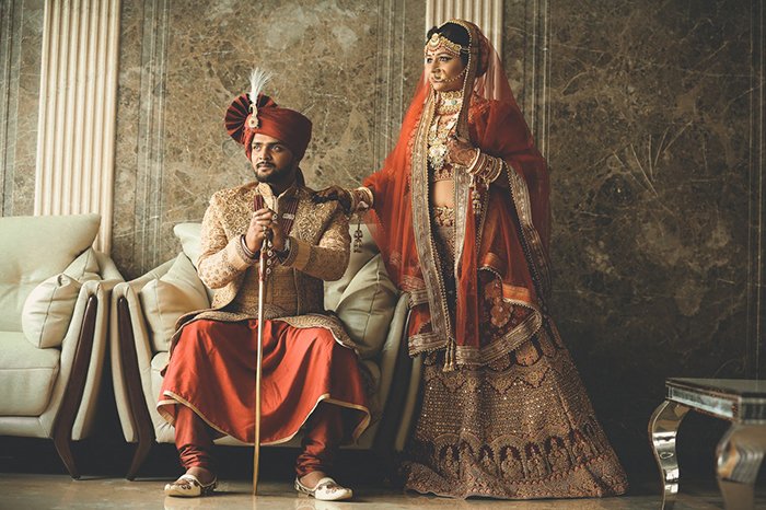 Hermoso retrato de boda de una pareja india posando con traje tradicional