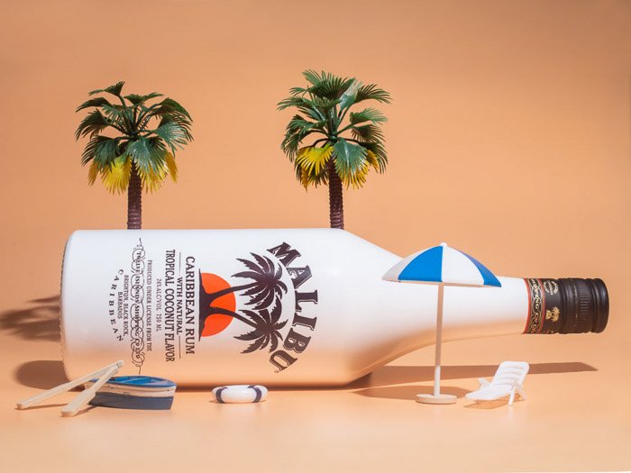 Una fotografía de un producto de estilo de vida de una botella de malibu contra un fondo naranja