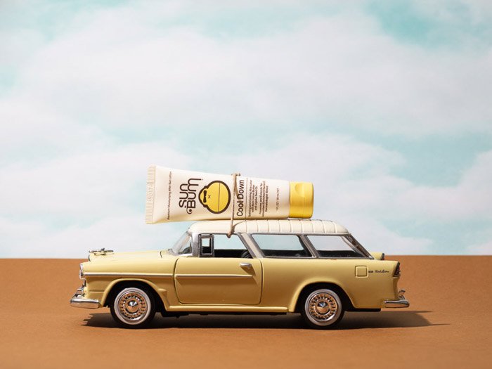 Fotografía de producto de estilo de vida con una botella de protector solar en el techo de un auto en miniatura