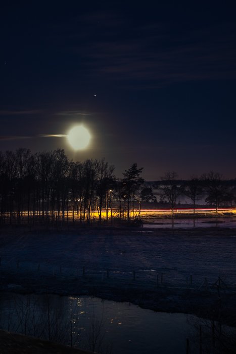 Estelas de luz en una noche de invierno bajo la Luna llena (con Júpiter al lado).