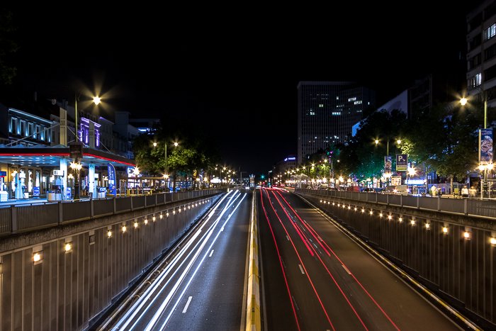Coches invisibles en una autopista de Bruselas con estelas de luz