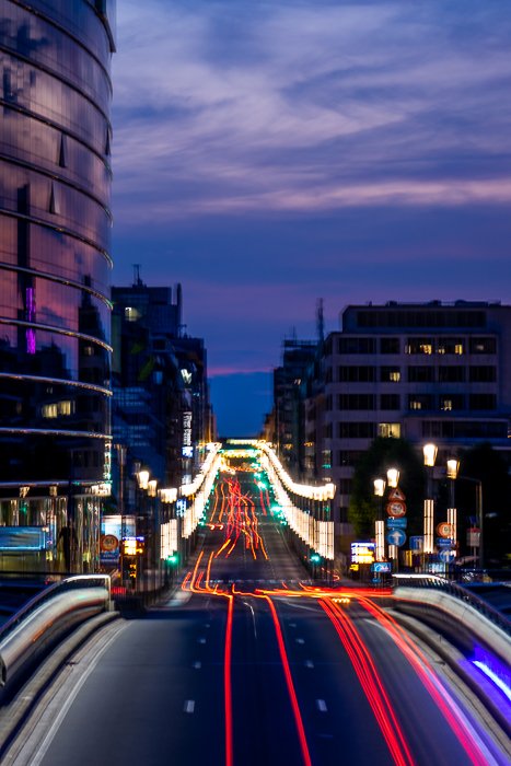 Paisaje urbano con trenes ligeros en una concurrida autopista justo antes del anochecer.