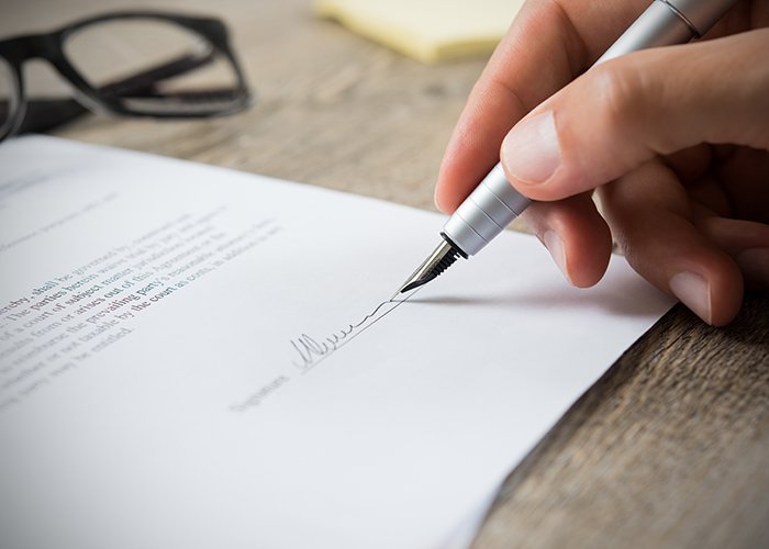 Hombre firmando un contrato.